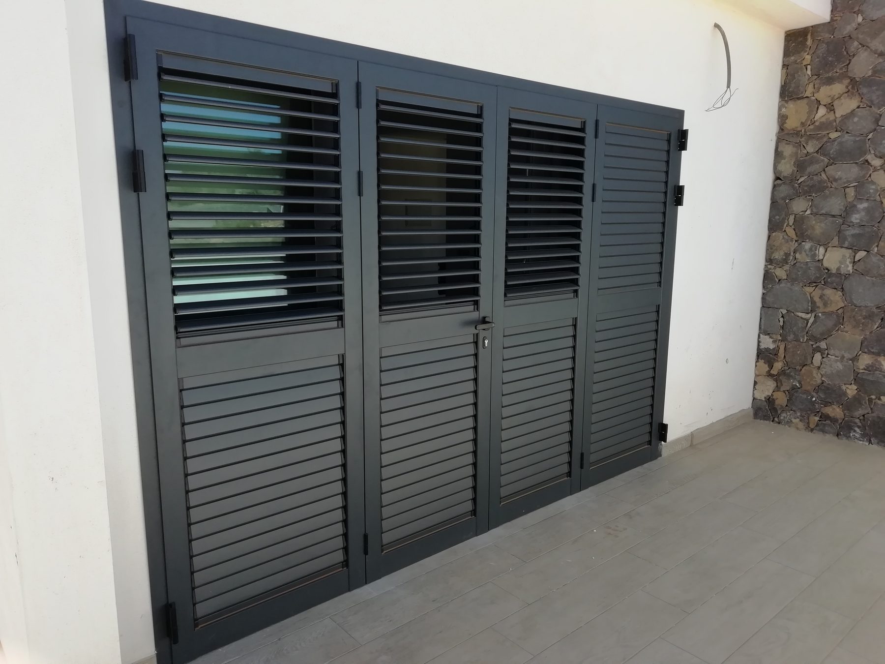 Mallorquinas de aluminio gris sobre fachada blanca