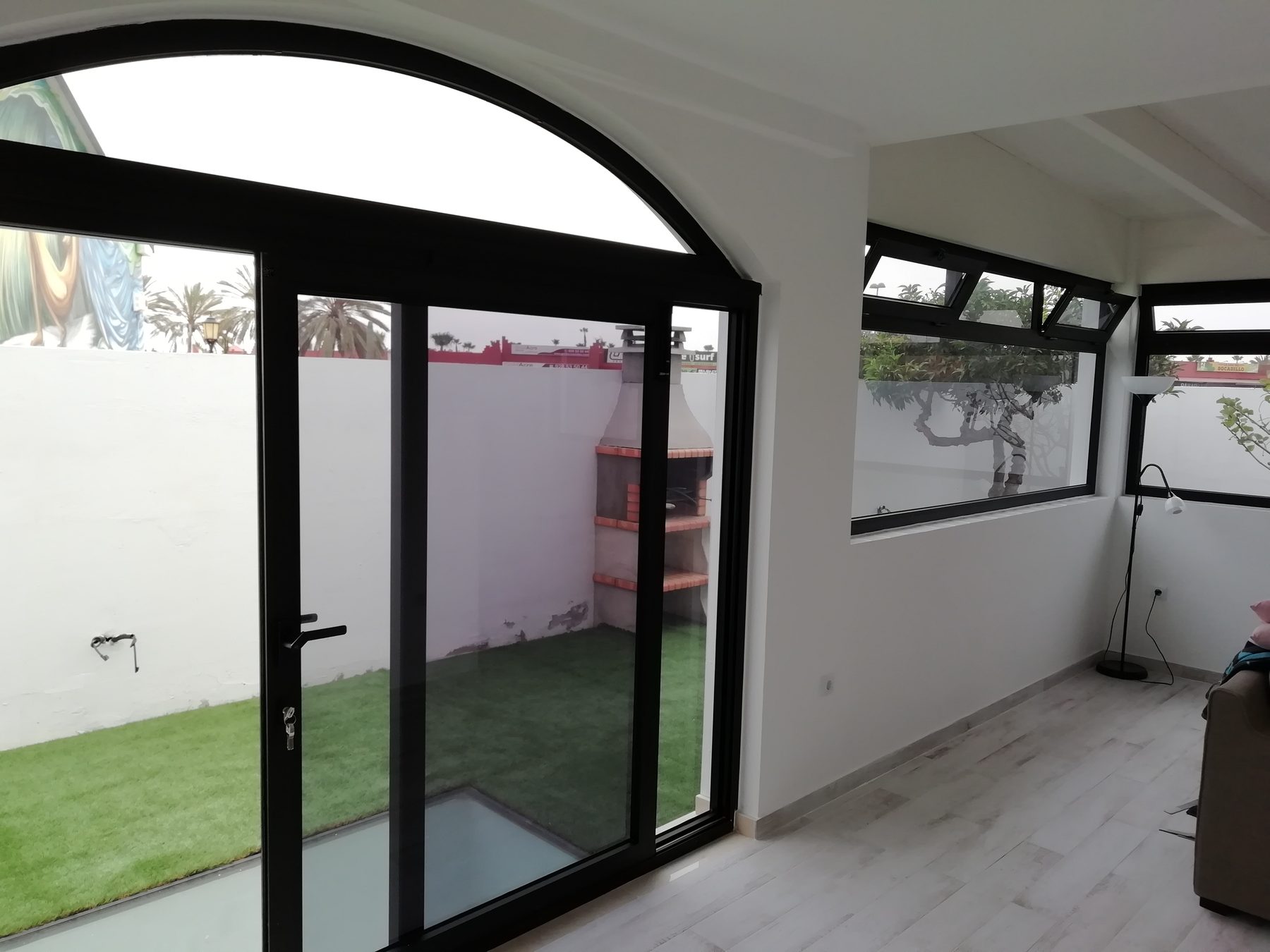 Ventana de arco y corredera negra en salón