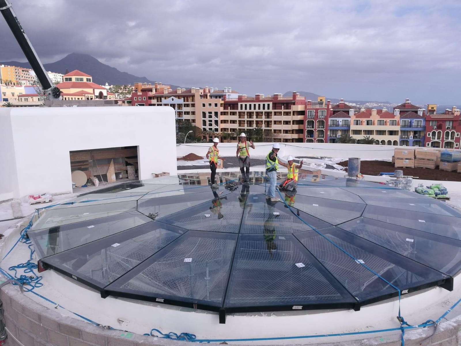 Equipo montando una cúpula acristalada sobre un hotel